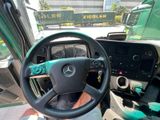 a steering wheel and dashboard of a green bus
