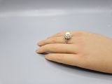 une image représentant la main d'une femme portant une bague en perle