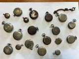 many different types of pocket watches displayed on a table