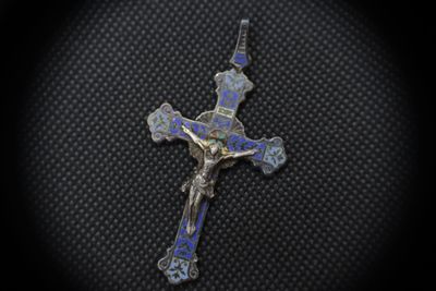 a silver cross with a blue and white enamel cross on it