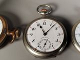 three different types of pocket watches sitting on a table
