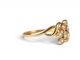 a close up of a gold ring with pearls on a white background