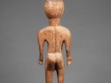 a wooden statue of a man standing on a pedestal