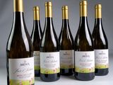 six bouteilles de vin sont alignées sur une table