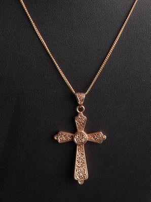 un pendentif en forme de croix en or sur un collier de mannequin