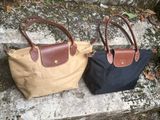 two brown and black bags sitting on top of a stone slab