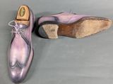 pair of men ' s purple leather shoes on a grey surface