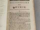 an old book with writing on it sitting on a table