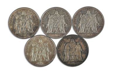six pièces d'argent de tailles et de formes différentes sur un fond blanc