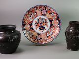 three vases and a plate sitting on a table