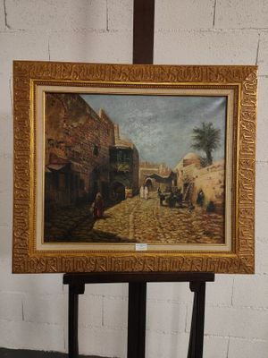 une photo d'un tableau posé sur un chevalet devant un mur de briques