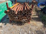 a pile of rusty pipes on the ground next to a fence