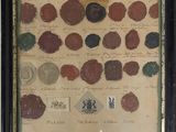 framed photograph of a collection of coins and other items on a wall