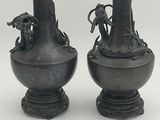 two black vases sitting next to each other on a table