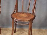 pair of wooden chairs sitting on top of a hard wood floor