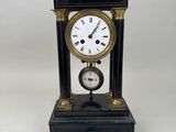 une horloge posée sur une table à côté d'une clé