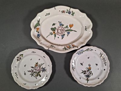three plates with flowers on them on a table