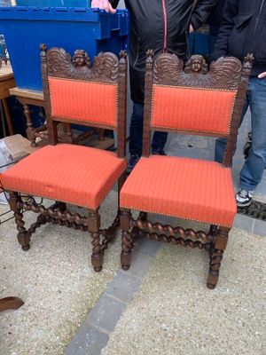 two men standing next to a set of four chairs