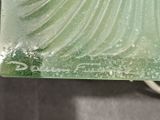 a green glass plate with a wave design on it