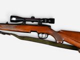 the rifle is laying on its side with a scope on it