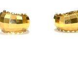 a pair of gold earrings that are on a white surface
