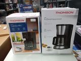 deux cartons contenant des cafetières posés sur une table dans un magasin