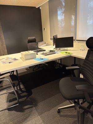 une photo d'une salle de conférence avec un écran de projection accroché au mur