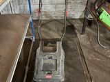 une tondeuse à gazon qui traîne dans un garage