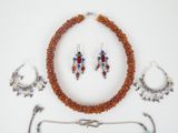 a necklace, bracelet, and earring set on a white surface