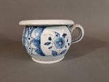 a blue and white vase with a handle on a table