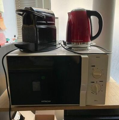 two microwaves sitting on top of each other on a table
