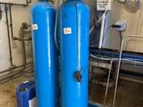 two blue water softener tanks in a room
