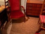 une chaise rouge et un bureau dans une petite pièce