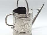 a silver watering can with a handle on a white background