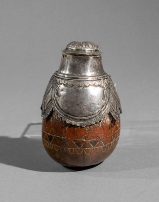 an old silver vase with a bird on top of it
