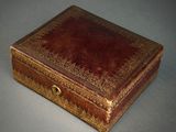 une boîte en cuir marron ornée d'un motif doré
