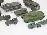 many toy army vehicles and trucks on a white surface