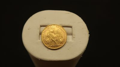 an image of a gold coin sitting on top of a white object