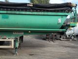 a green truck with a black tarp on the back