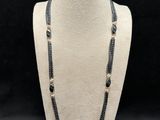 a black and white beaded necklace on a mannequin neck