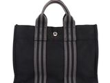 a black tote bag with grey stripes on the side