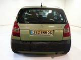 a small green car parked in a white room