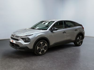 a silver suv parked in a room with a white wall