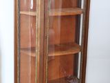 a wooden cabinet with a glass door in a room