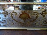 a mirror with a gold leaf on it on a table