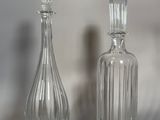 deux bouteilles en verre posées l'une à côté de l'autre sur une table