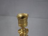 a gold candle holder on a glass table