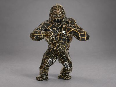 a close up of a figurine of a gorilla on a gray background