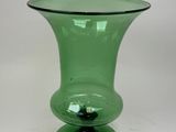 un vase en verre vert posé sur une table blanche