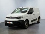 une camionnette blanche garée dans une pièce aux murs blancs